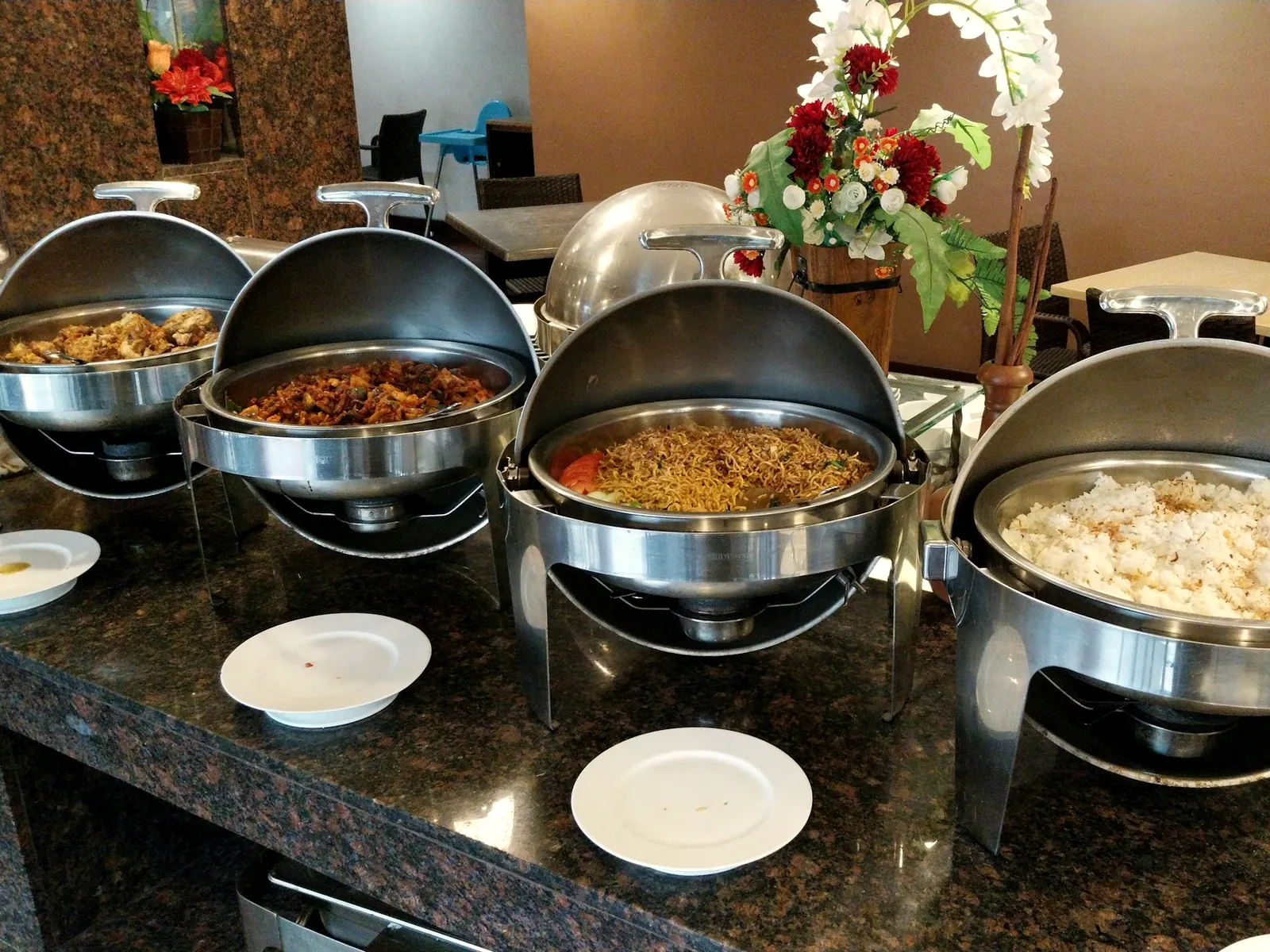 Chafing dishes of Indian curries and rice laid out on a buffet counter