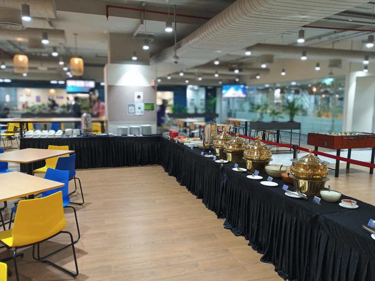 A buffet line of gold chafing urns in an office cafeteria