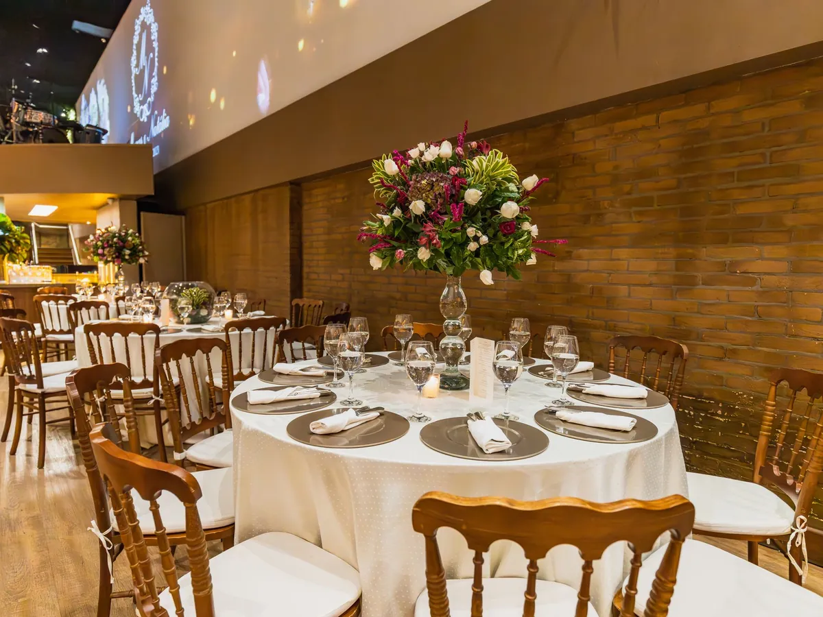 A reception table set with chiavari chairs and a tall floral centrepiece