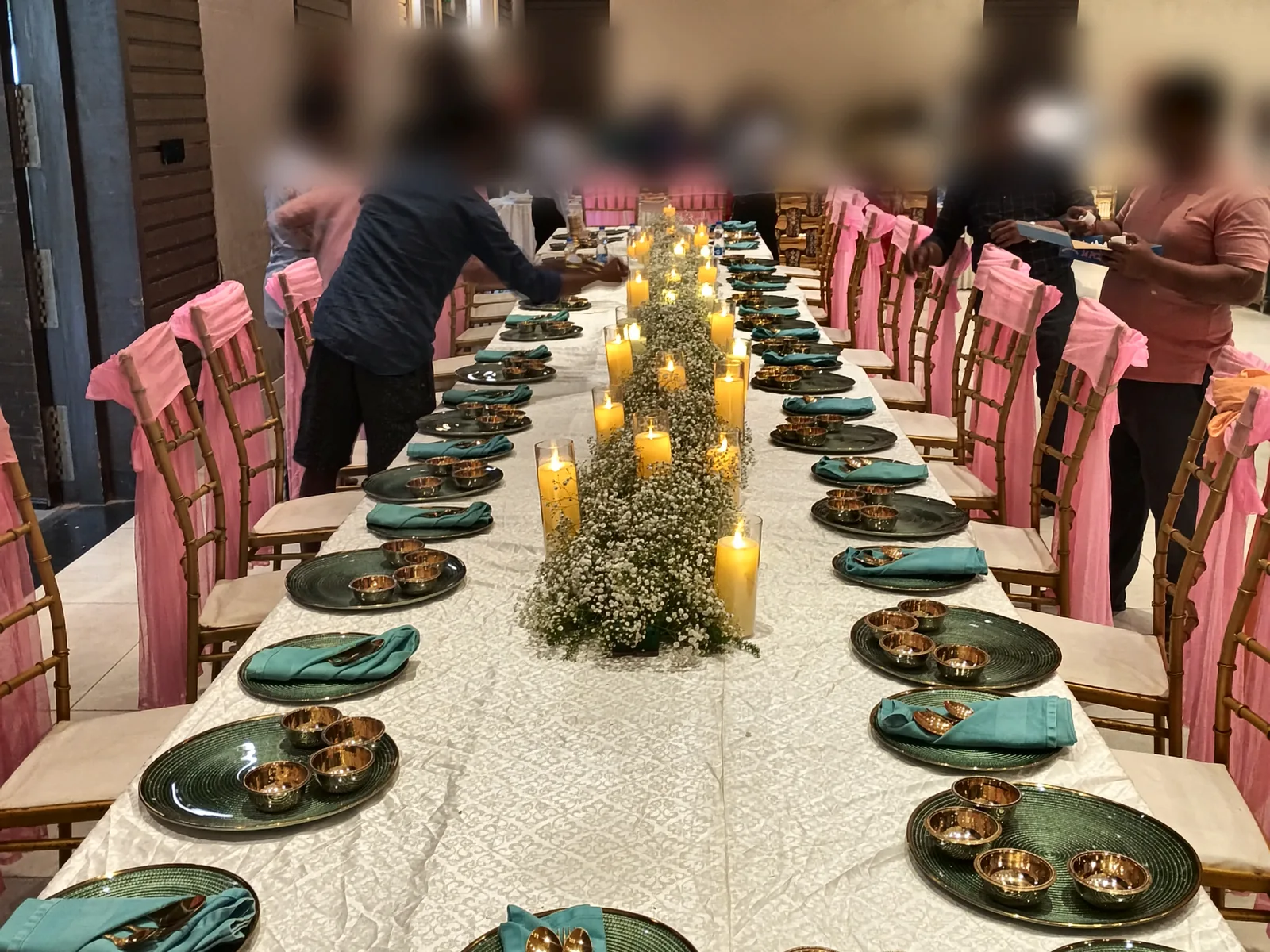 Staff setting the reception table before guests sit down, at a reception Flavours Tec Kitchen catered